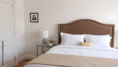 Elegant bedroom with a neatly made bed, white linens, and a stylish headboard.