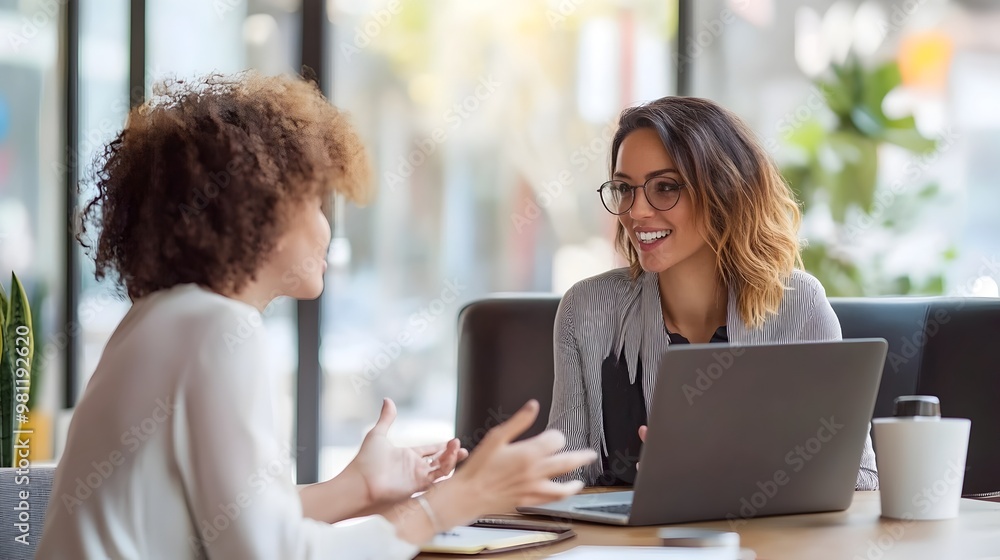 Two Smiling Professionals Discussing Laptop During Business Meeting in Cozy Office Two Smiling Professionals Discussing Laptop During Business Meeting in Cozy Office