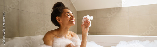 Photography Woman bathes in foamfilled bathtub, smiling happily
