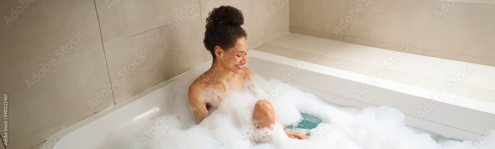 Woman enjoying a foamfilled bath in a bathtub, relaxing in the bathroom Woman enjoying a foamfilled bath in a bathtub, relaxing in the bathroom