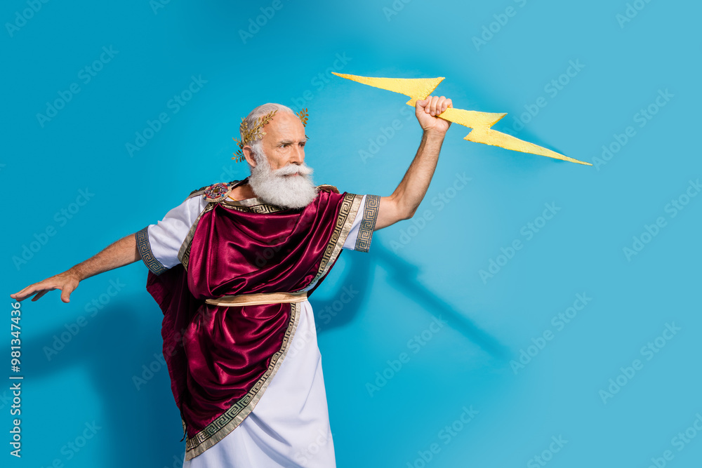 Photo of powerful mature man strike lightning wear ancient roman emperor tunic isolated on blue color background Photo of powerful mature man strike lightning wear ancient roman emperor tunic isolated on blue color background