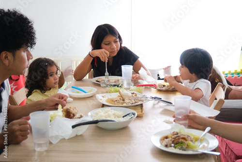 Happy latin family enjoying their lunch all together at their home table