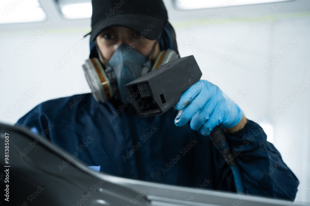Using anti static gun to prevent damages and remove dust before covering car with paint. Mechanic is working with anti static gun to prepare metal for paintwork Using anti static gun to prevent damages and remove dust before covering car with paint. Mechanic is working with anti static gun to prepare metal for paintwork