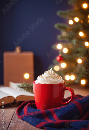 Red of cocoa, hot chocolate or coffee with whipped cream on a wooden table with red knitted plaid in front of a Christmas tree. Merry Christmas or New Year concept for banner with copy space. 