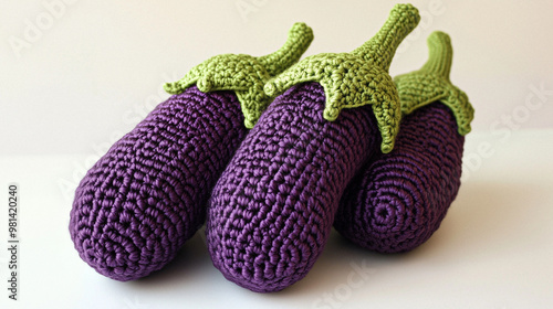 A variety of crocheted vegetables such as eggplants, tomatoes, and artichokes, arranged in a vibrant and playful display.  photo