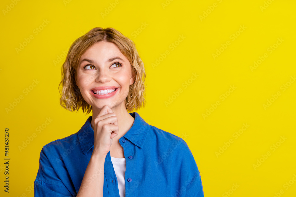 Portrait of pretty young lady look empty space wear blue shirt isolated on yellow color background Portrait of pretty young lady look empty space wear blue shirt isolated on yellow color background