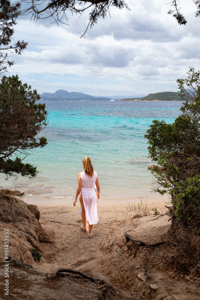 Woman in White Dress Strolling Toward Scenic Beach View Woman in White Dress Strolling Toward Scenic Beach View