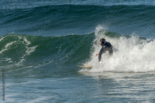 Surfer riding a wave on an Atlantic Ocean beach.