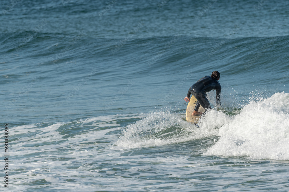 Surfer riding a wave on an Atlantic Ocean beach. Surfer riding a wave on an Atlantic Ocean beach.