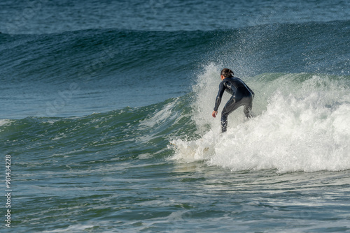 Surfer riding a wave on an Atlantic Ocean beach.