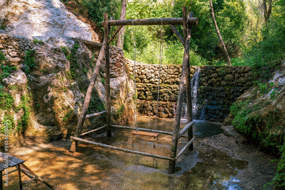 Rustic Wooden Swing Near Tranquil Waterfall in Forest