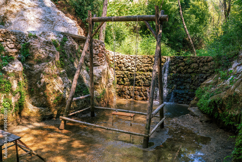Obraz na płótnie Rustic Wooden Swing Near Tranquil Waterfall in Forest w salonie