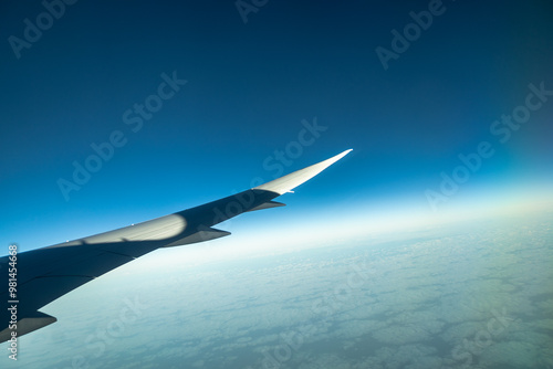 Wing of plane taking off at dawn with beautiful scenery in the background. Concept: Airplanes, holidays, travelling.