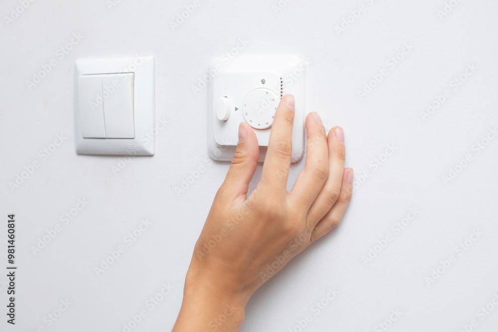 Woman adjusting lighting with dimmer lever, closeup. An electronic device designed to change electrical power Woman adjusting lighting with dimmer lever, closeup. An electronic device designed to change electrical power