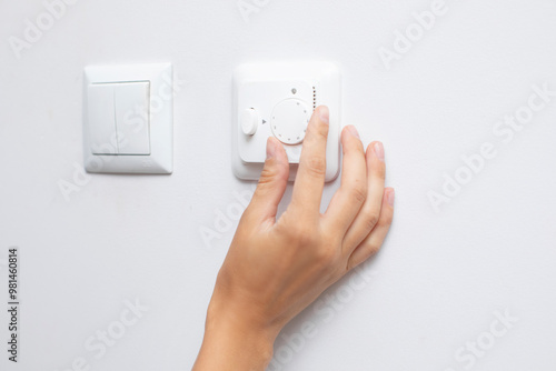 Woman adjusting lighting with dimmer lever, closeup. An electronic device designed to change electrical power