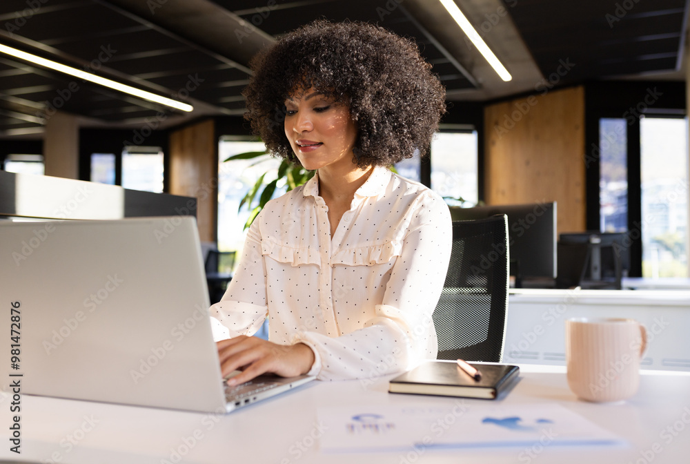 Working in office, woman using laptop and writing in notepad, focusing on tasks Working in office, woman using laptop and writing in notepad, focusing on tasks