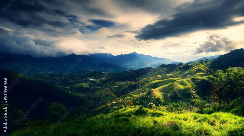Fototapeta premium Rolling green hills in a mountain range with a dramatic, stormy sky.