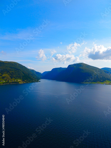 Experience the stunning view of a serene lake beautifully surrounded by majestic mountains