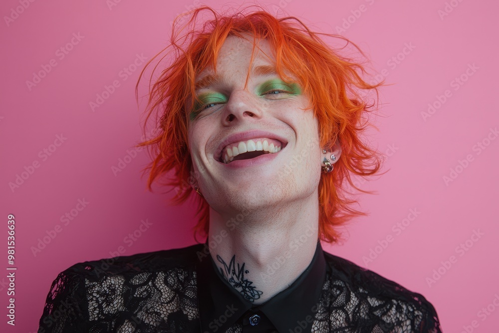 Vibrant portrait of a laughing man with bright orange hair and green eye makeup against a pink background wearing lace clothing Vibrant portrait of a laughing man with bright orange hair and green eye makeup against a pink background wearing lace clothing