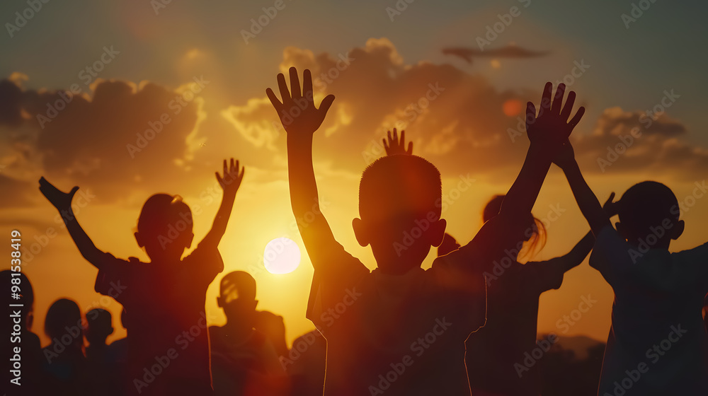 Fototapeta premium Silhouette of a refugee child group playing at sunset, with raised hands in worship, representing hope, freedom, faith, and praise