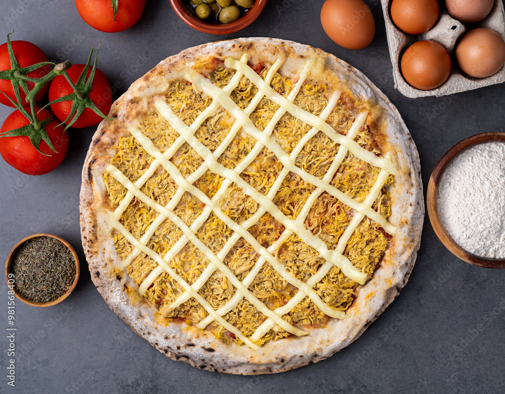Chicken and Catupiry cream cheese pizza over stone background with flour, olives, tomatoes and eggs Chicken and Catupiry cream cheese pizza over stone background with flour, olives, tomatoes and eggs
