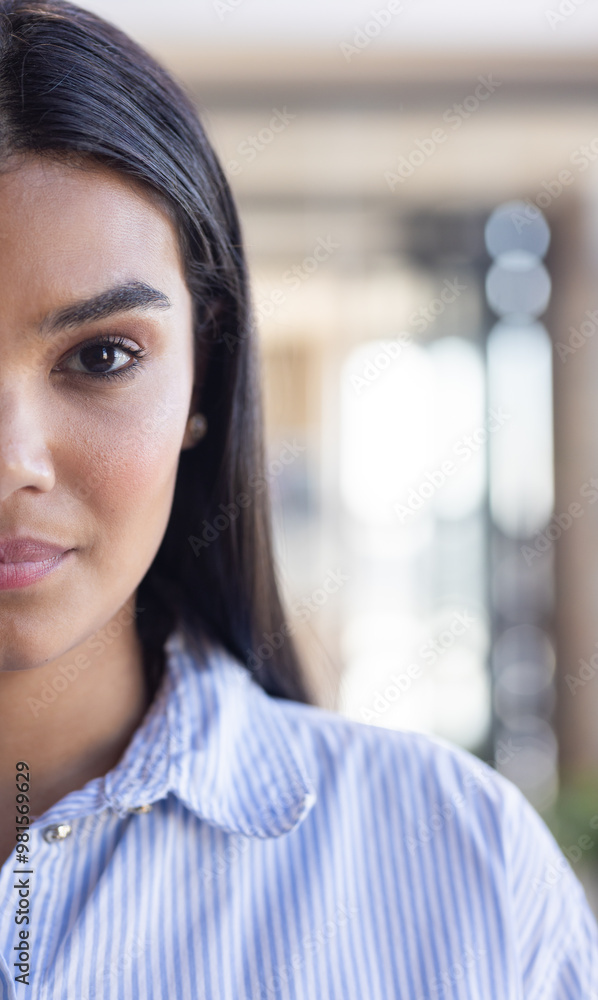 Close-up of woman in striped shirt, looking confident in business setting Close-up of woman in striped shirt, looking confident in business setting