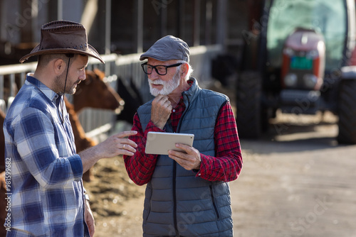 Wallpaper Mural Two farmers using tablet on cow farm Torontodigital.ca