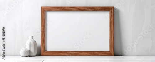 A minimalist wooden frame displayed on a light wall beside a decorative vase in a serene indoor setting