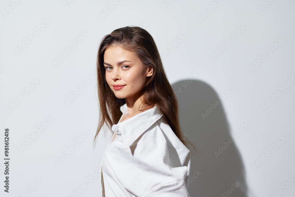 Portrait of a confident young woman with long hair smiling against a soft light gray background, showcasing natural beauty and effortless charm, emphasizing youthfulness and positivity Portrait of a confident young woman with long hair smiling against a soft light gray background, showcasing natural beauty and effortless charm, emphasizing youthfulness and positivity