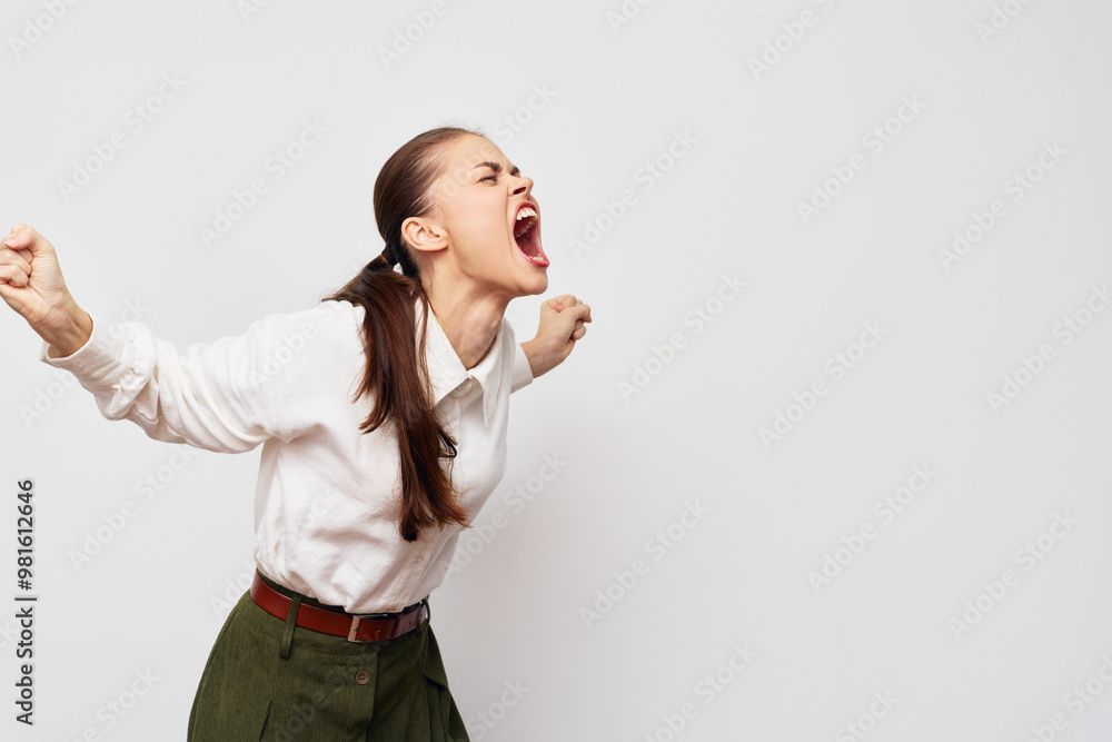 Emotional woman expressing anger and frustration with a loud scream on a plain white background, showcasing strong feelings and intense emotion in a professional setting Emotional woman expressing anger and frustration with a loud scream on a plain white background, showcasing strong feelings and intense emotion in a professional setting