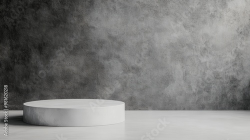 A prominent white concrete pedestal is center-framed against a dark textured background, presenting a contrast in tones, emphasized through simplicity and modern elegance. photo