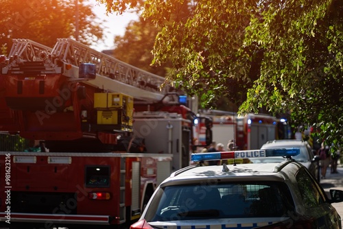 Photography Firefighters and police respond to emergency, fire trucks with ladders and flashing blue lights
