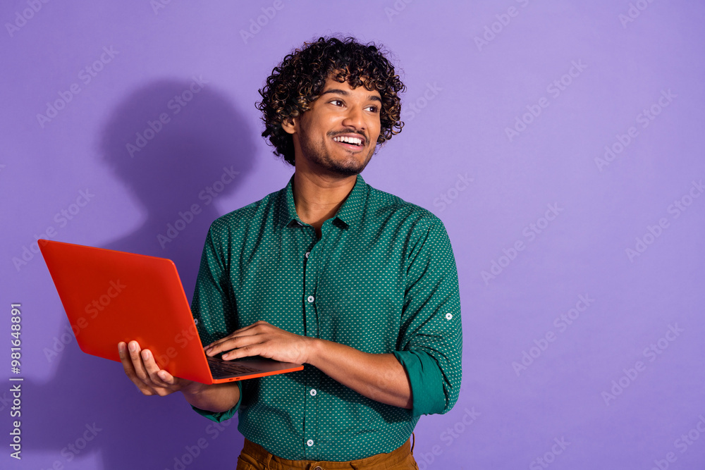 Photo portrait of funny latin guy it courses coach using laptop looking his project wearing green casual shirt isolated on violet color background Photo portrait of funny latin guy it courses coach using laptop looking his project wearing green casual shirt isolated on violet color background