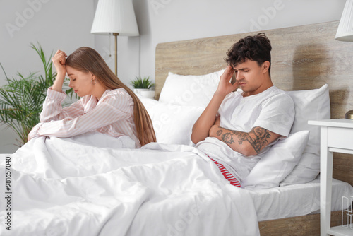 Sad young couple in bedroom...