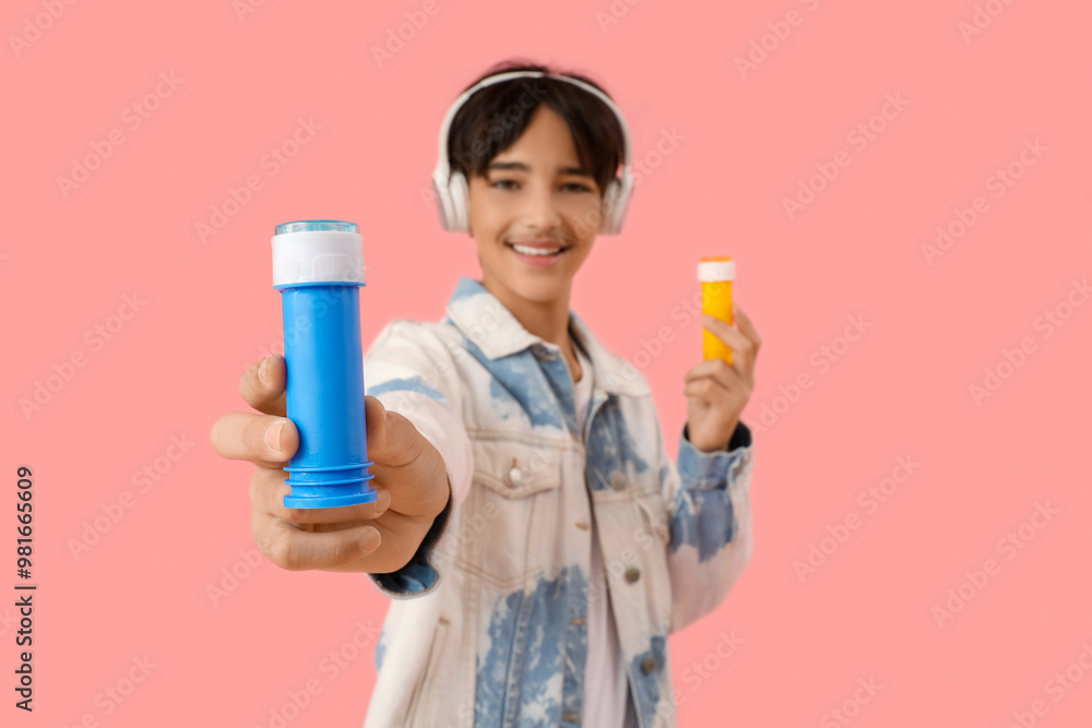 Teenage boy in headphones with soap bubbles on pink background, closeup Teenage boy in headphones with soap bubbles on pink background, closeup