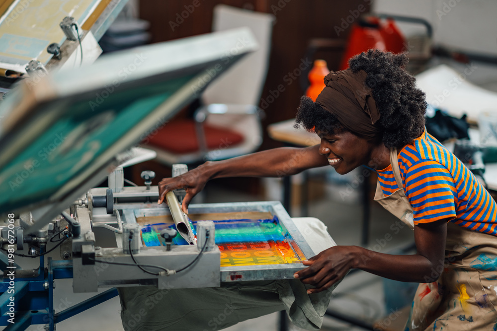 Happy female diverse worker silkscreen printing on machine at workshop Happy female diverse worker silkscreen printing on machine at workshop