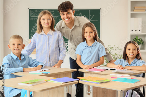 Male teacher with little pupils in classroom