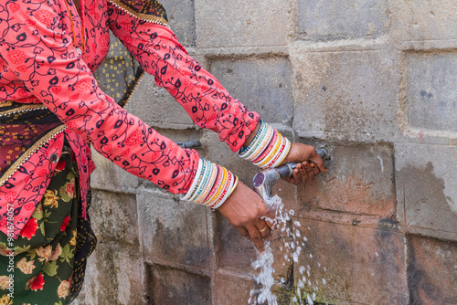 Woman at a public drinking water tap. photo