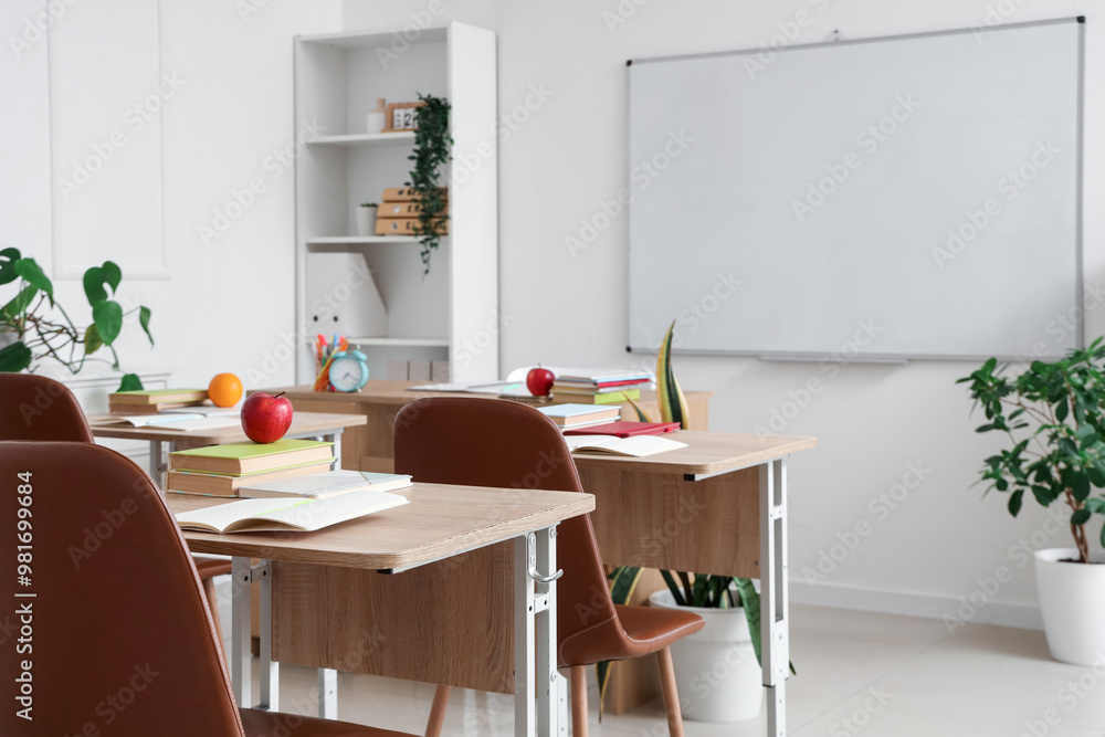 Fototapeta premium Interior of empty classroom with school desks and clean whiteboard