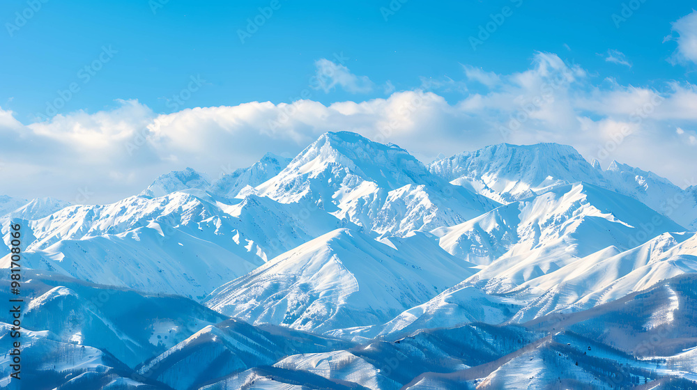 A snow-capped mountain range under a clear blue sky with white clouds. A snow-capped mountain range under a clear blue sky with white clouds.