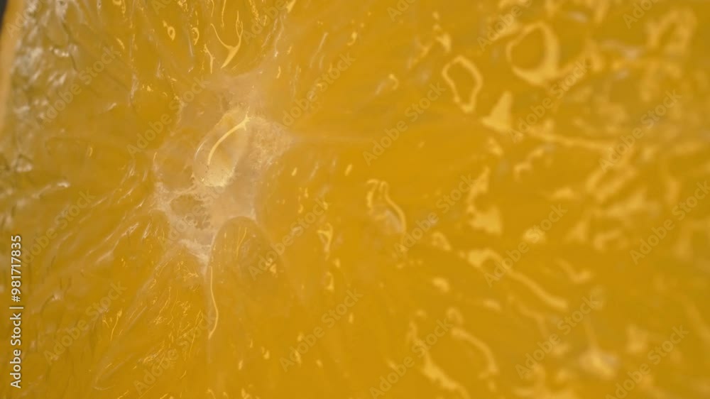 The macro photography of a sliced orange with vibrant orange color and visible in the juicy flesh of the citrus fruit. The flesh of the orange appears plump, hinting at its juiciness. Comestible. The macro photography of a sliced orange with vibrant orange color and visible in the juicy flesh of the citrus fruit. The flesh of the orange appears plump, hinting at its juiciness. Comestible.