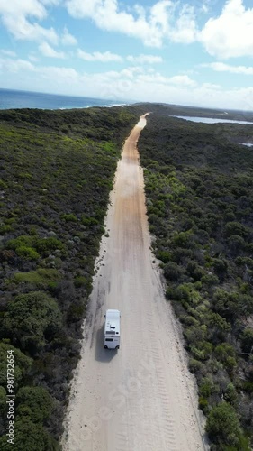 Driving Down an Empty Road in Western Australia's Outback with White Sand, Green Forest, and Ocean Views