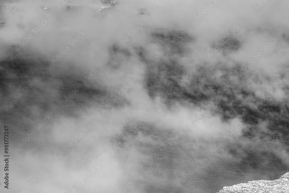 Fototapeta premium Photograph of Black and white photograph of hot steam rising from the water surface of a geyser