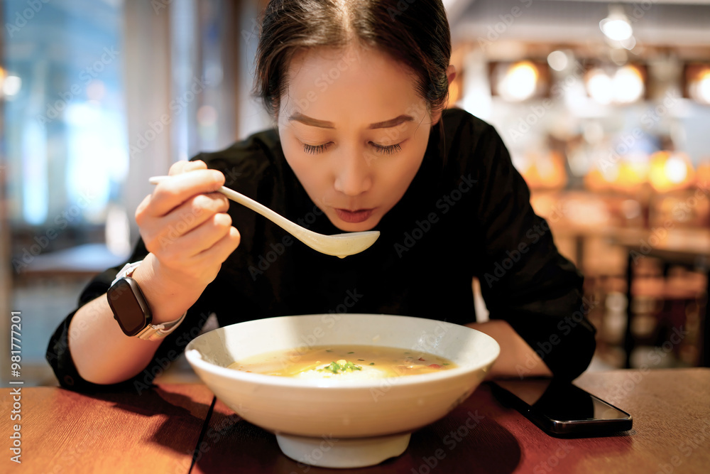 Enjoying a Delicious Bowl of Noodle Soup in a Modern Restaurant Setting