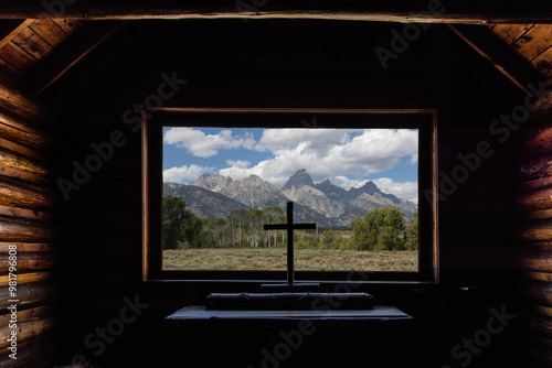 Photos Photo from inside the Chapel of the transfiguration looking out of large window with cross at the grand Tetons Mountain peaks