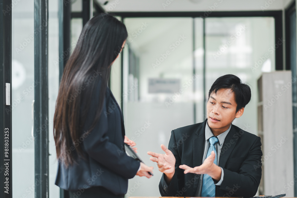 Two business professionals engaged in a serious discussion in a modern office environment, emphasizing teamwork and collaboration. Two business professionals engaged in a serious discussion in a modern office environment, emphasizing teamwork and collaboration.