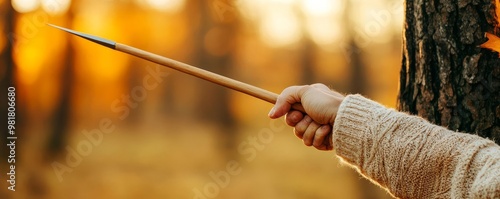 Person practicing spear throwing at a tree target, camping survival, primitive weapon skills photo