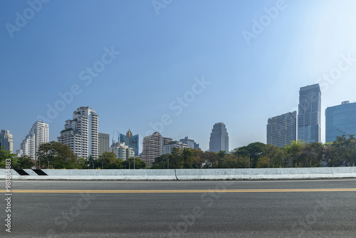 Asphalt road and city skyline with modern buildings scenery. Side view of asphalt road.