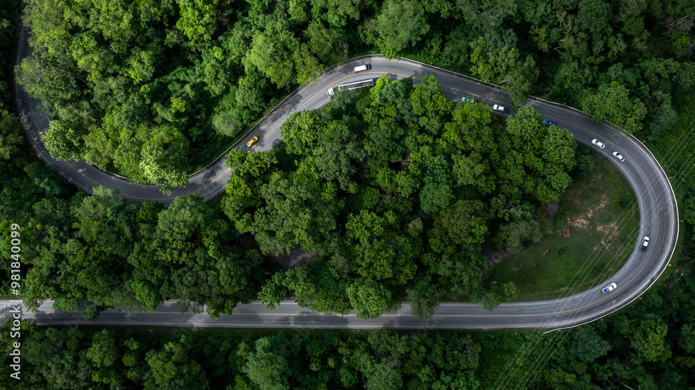 Aerial view car drive in green tree forest road winding road through the forest, Car drive on asphalt road between green tree forest, Electric vehicle EV car drive on asphalt road green tree forest. Aerial view car drive in green tree forest road winding road through the forest, Car drive on asphalt road between green tree forest, Electric vehicle EV car drive on asphalt road green tree forest.