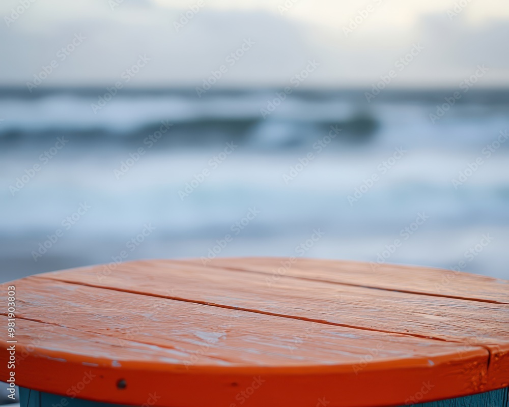 Detailed orange tabletop, blurred ocean horizon and gently rolling waves in the background Detailed orange tabletop, blurred ocean horizon and gently rolling waves in the background